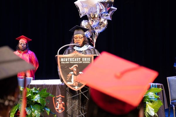 Adult speaking at podium during graduation ceremony.